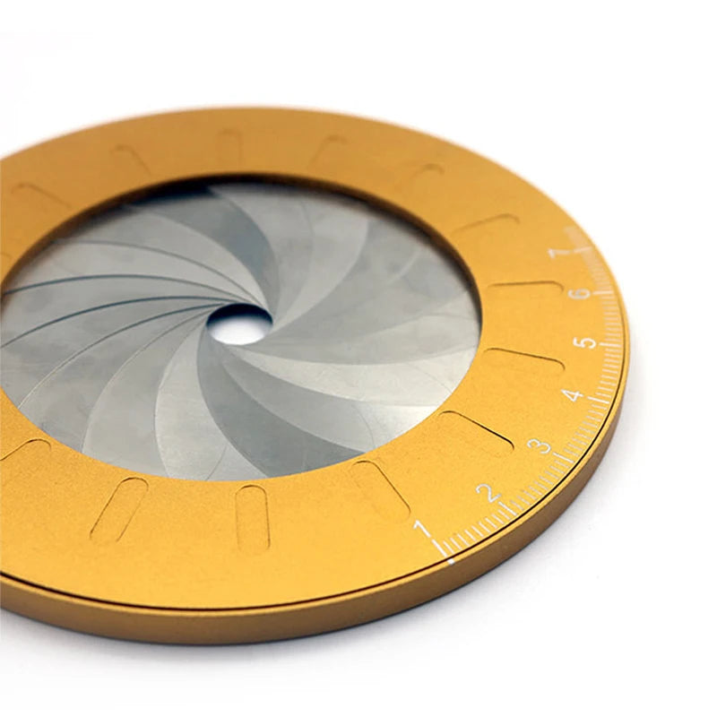 A round, gold-colored drawing compass ruler with a silver-gray rotating scale and markings.