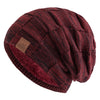 A maroon knit beanie with a diamond pattern and a faux fur trim.