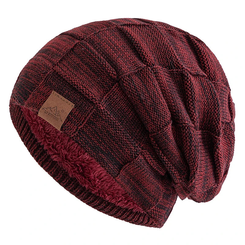 A maroon knit beanie with a diamond pattern and a faux fur trim.