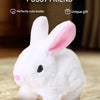 A white bunny plush toy with pink inner ears is shown on a wooden surface.