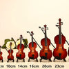 Un ensemble d'instruments de musique miniatures : violon, guitare et ukulélé disposés sur une surface.