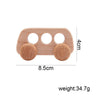 A light wood hand-pushed cart toy for toddlers with four circular openings and two round wooden wheels.