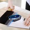 A hand is using an electric knife sharpener with a protective cover to sharpen a blade.
