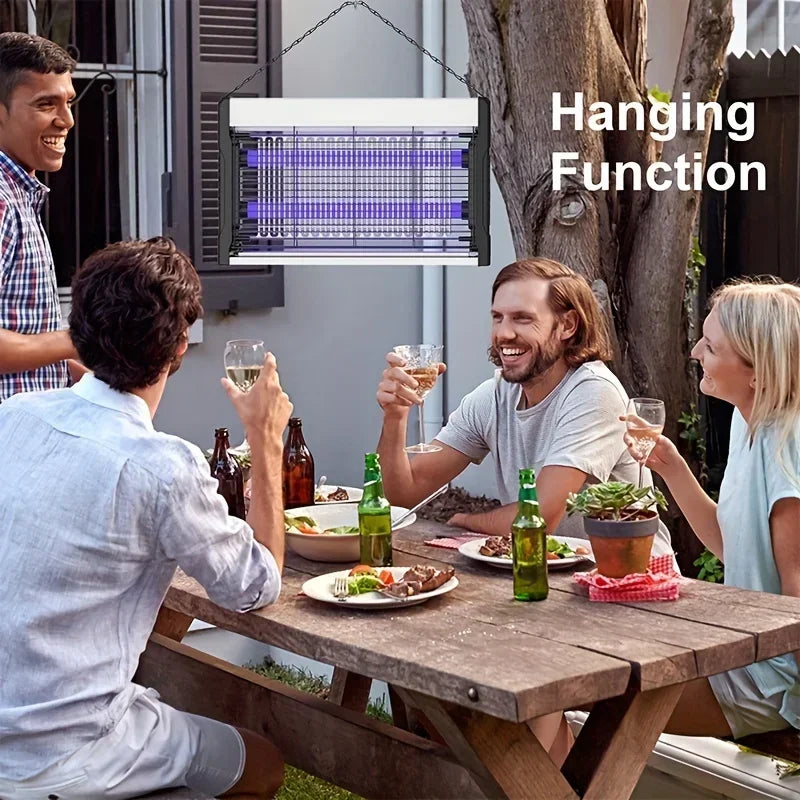 A man is enjoying a meal outdoors while an electric mosquito killer lamp with UV light trap is shown hanging above.