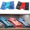 A set of colorful clothes folding boards and a stack of neatly folded light blue, pink, and gray shirts.