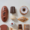 A collection of wooden pretend play food items including a donut, bread, and cheese slices.