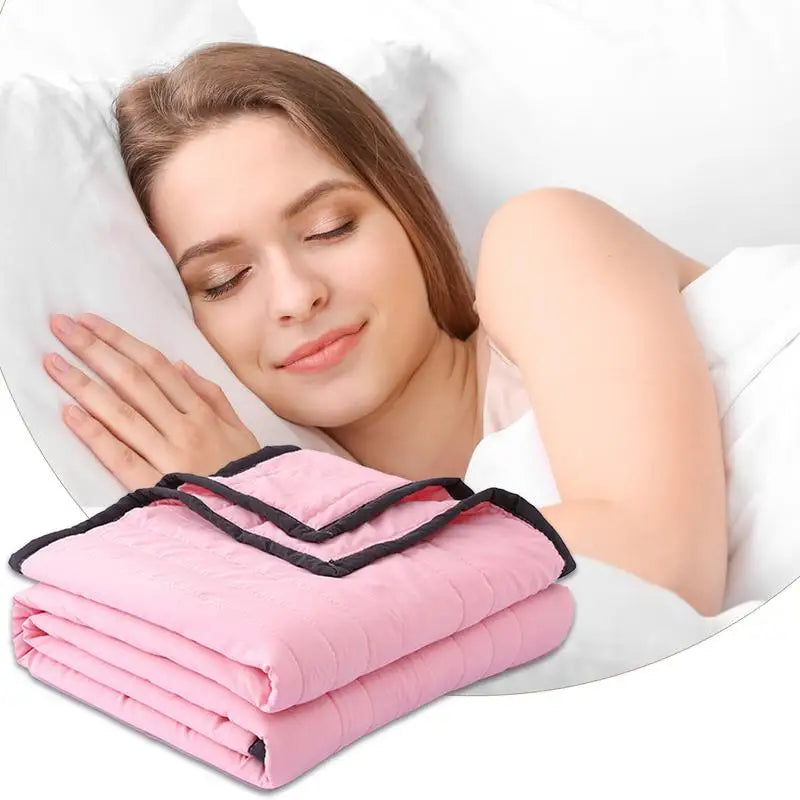 A woman is relaxing with a pink breathable cooling throw blanket on her arm while resting in bed.