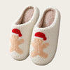 A pair of white, fluffy winter slippers with red Santa-themed accents.