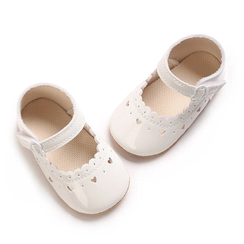 A pair of white baby first walker shoes with perforated details and soft lining.