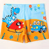 Boys' quick-dry dinosaur swim trunks featuring a blue dinosaur and a blue car on an orange background
