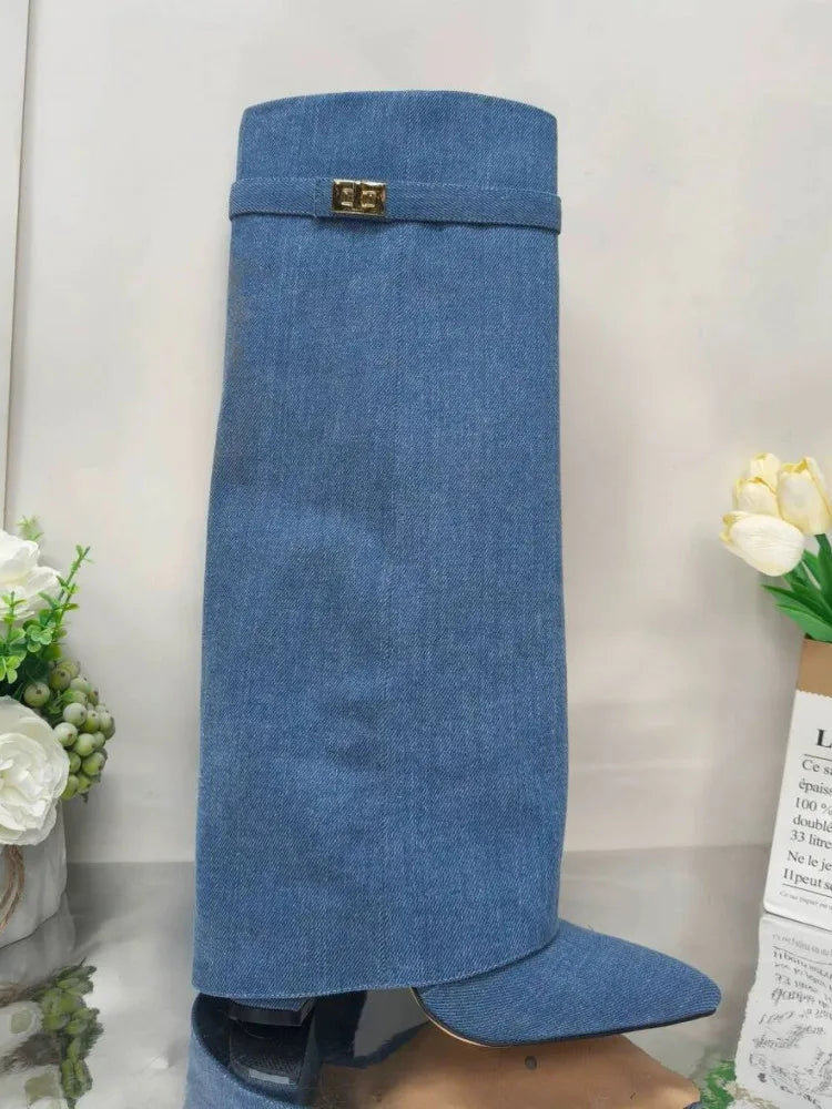 A full-length view of a navy blue knee-high boot with a chunky heel and a gold metal buckle.
