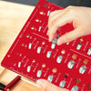 A hand is using a red bolt and nut thread identifier gauge to measure various standard sizes of bolts and nuts.