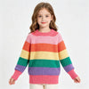 A young girl models a colorful rainbow striped knit sweater with long sleeves.