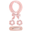 Pink satin heatless overnight curling headband tied in a bow with a rectangular clip.