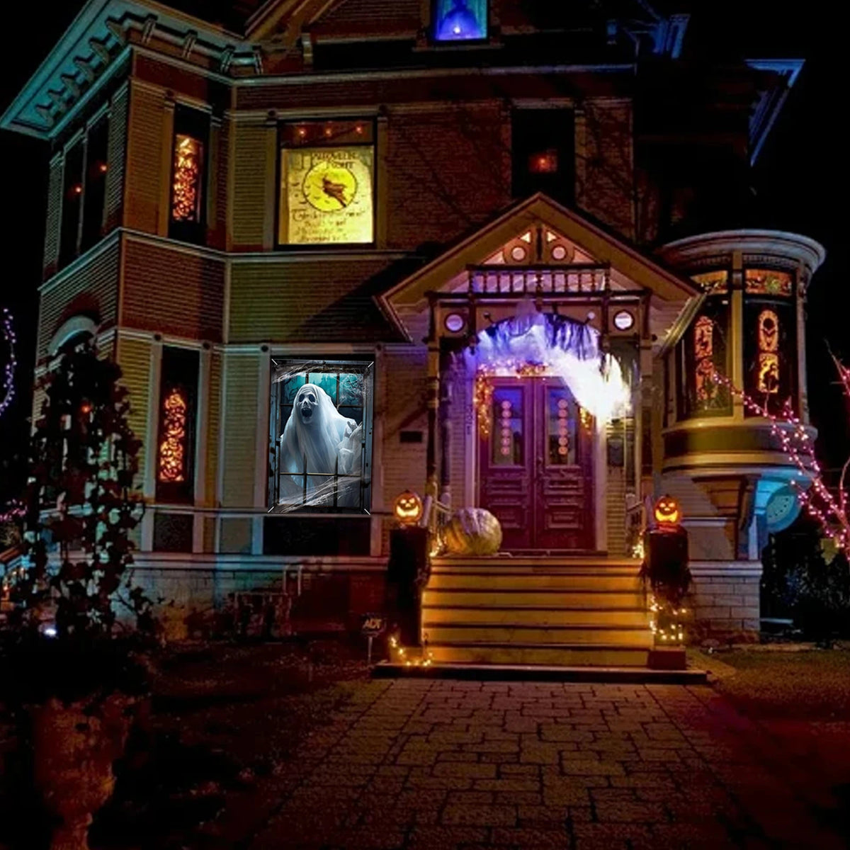 A house decorated for Halloween with spooky window clings and glowing lights on the entrance.