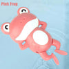 A pink frog bath toy is shown floating in clear water.
