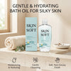 En flaske Skin So Soft badeolie ved siden af emballage og et håndklæde, der fremmer skånsom fugtgivning og nærende hudpleje.