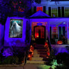 A haunted house facade decorated for Halloween with purple lighting, a spooky window, and an illuminated entrance.