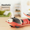 A realistic electric snake cat toy in red and white scales resting on a wooden surface.