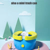 A blue foldable potty for kids is shown on a pink tray with small plastic items nearby.
