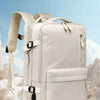 Sac à dos crème posé sur une surface blanche, mettant en avant ses caractéristiques de voyage extensibles.