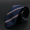 Corbata azul oscuro con rayas diagonales rojas y blancas, plegada sobre fondo oscuro.