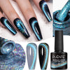 Un ensemble de capsules d'ongles bleu et violet iridescents, incluant un gel œil de chat laser nébuleuse et une colle à ongle