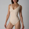 En modell iført en beige sømløs magekontrollerende truse-body.