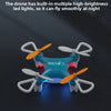 A blue mini drone with LED lights is shown in flight, demonstrating night flight capability.