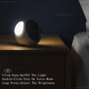 A white, spherical night light device is placed on a wooden surface.