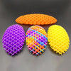 Tres juguetes antiestrés tipo gusano elástico 3D de colores brillantes: naranja, morado y amarillo, dispuestos sobre una supe