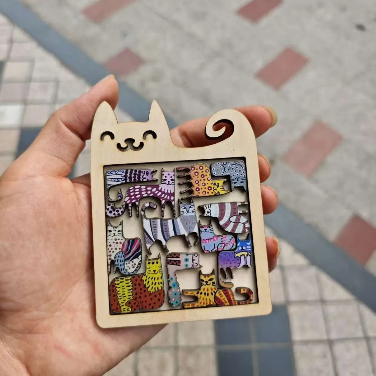 Rompecabezas de madera en forma de gato con piezas coloridas y estampadas.