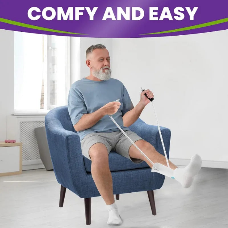 A man is using a white sock aid on his foot while sitting in an armchair.