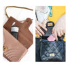 A close-up of a brown leather organizer pouch and a black quilted fabric pouch with a pink accent.