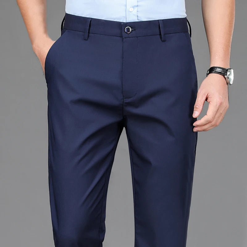 Navy blue men's stretch straight-leg trousers with a light blue shirt visible.