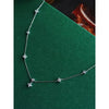 A silver heart pendant necklace with simulated pearls displayed on a green velvet background.