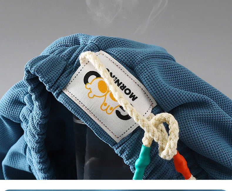 Blue knitted kids beach shorts with an elastic waist and a white tag visible.