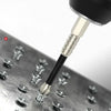 A close-up view of a black magnetic screwdriver bit with a hex shank resting on a metal surface.
