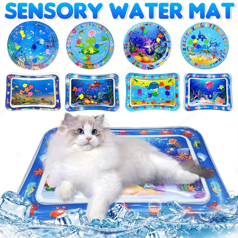 Un gato blanco y esponjoso juega en una alfombra sensorial de agua azul con diseños de peces coloridos.