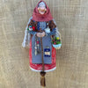 Handcrafted kitchen witch doll wearing a red and white dress and a patterned head covering