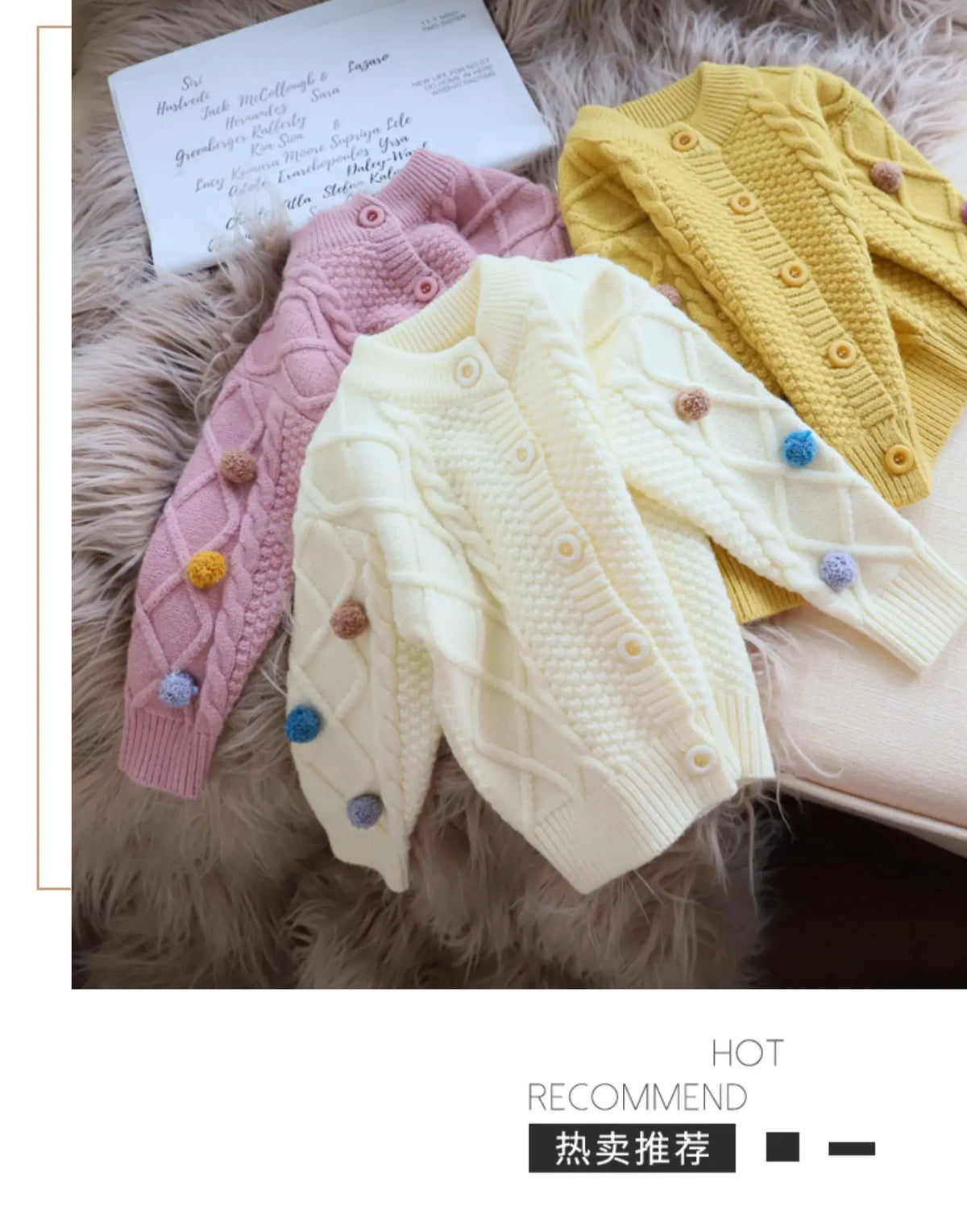 A display of three knitted cardigans in pink, cream, and yellow with pom-pom trim.