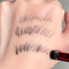 A hand is demonstrating an angled eyebrow brush applying dark cosmetic strokes to a person's eyebrow.