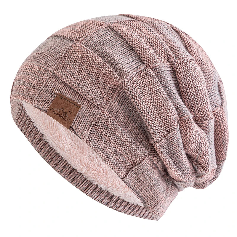 A pink knit beanie with a textured pattern and a light pink faux fur trim.