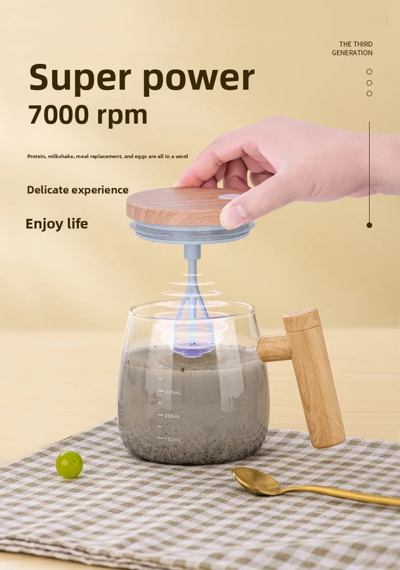 A hand is stirring a dark liquid in a glass mug using a blue self-stirring mechanism with a wooden handle.