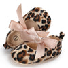 Pair of leopard print baby first walkers with soft pink ribbon accents and rubber soles