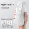 Eine Hand hält eine weiße Popcorn-Außensohle in einer Fußgewölbestützeinlage, die strukturierte Oberfläche wird gezeigt.