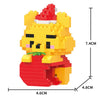 A yellow building block figurine of a bear wearing a red Santa hat and a red outfit.