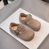 A pair of tan retro non-slip kids' moccasin shoes with an easy hook-and-loop closure displayed on a white card.