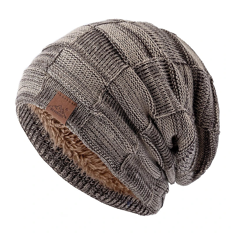 A beige and brown knit slouchy beanie with a multicolor pattern and a faux fur trim.
