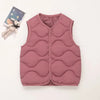 A pink quilted vest for a child is displayed next to a small stuffed animal.